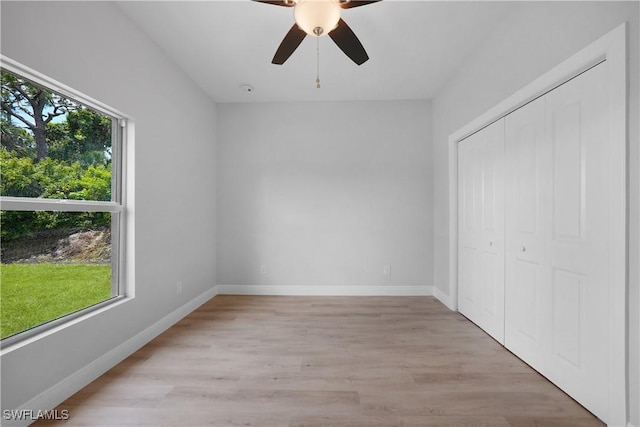 4201 17th St SW, Lehigh Acres, FL 33976 - unfurnished bedroom with light wood-type flooring, a closet, and a ceiling fan