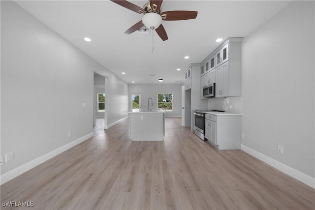 4201 17th St SW, Lehigh Acres, FL 33976 - kitchen featuring stainless steel appliances, recessed lighting, a center island with sink, light wood-type flooring, and ceiling fan