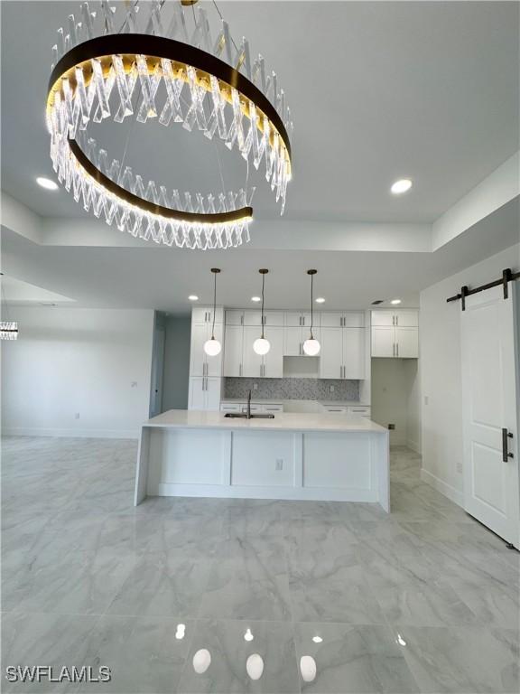 1009 Euclid Ave, Lehigh Acres, FL 33972 - kitchen with a barn door, a sink, light marble finish floors, white cabinetry, and recessed lighting