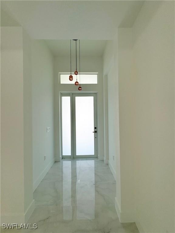 1009 Euclid Ave, Lehigh Acres, FL 33972 - hallway featuring light marble finish floors and baseboards