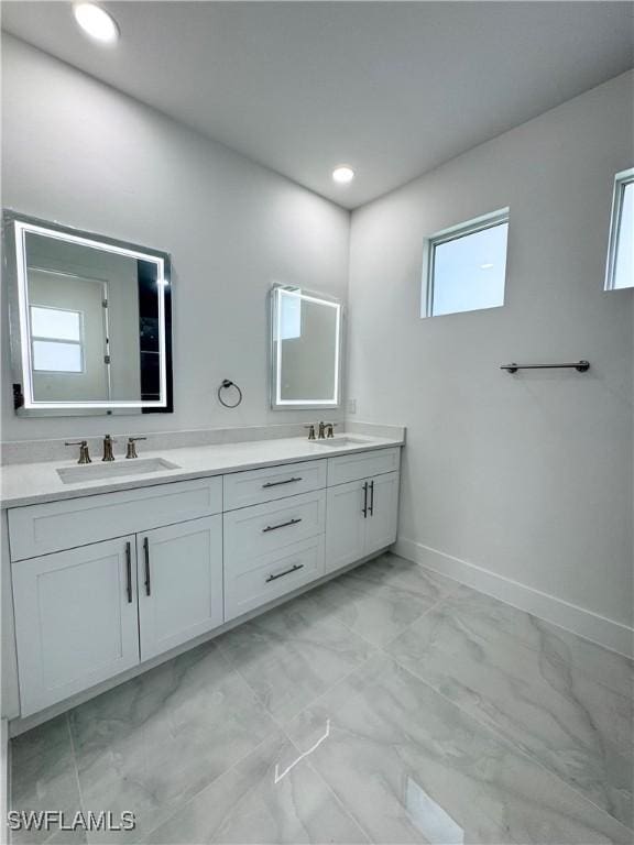 1009 Euclid Ave, Lehigh Acres, FL 33972 - full bath with marble finish floors, double vanity, recessed lighting, and baseboards