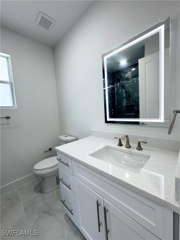 1009 Euclid Ave, Lehigh Acres, FL 33972 - bathroom featuring toilet, vanity, marble look tiles, and a shower