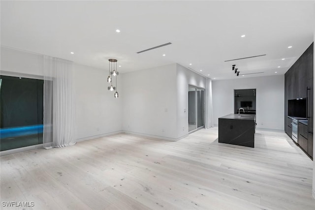 1135 Bluebird Ave, Marco Island, FL 34145 - unfurnished living room with light wood finished floors, a sink, recessed lighting, and baseboards