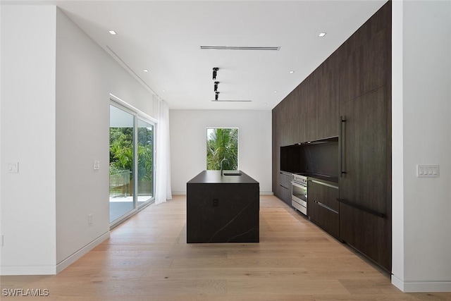 1135 Bluebird Ave, Marco Island, FL 34145 - kitchen featuring modern cabinets, wall oven, a sink, a center island with sink, and recessed lighting
