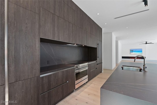 1135 Bluebird Ave, Marco Island, FL 34145 - kitchen with stainless steel range with electric stovetop, a sink, modern cabinets, light wood-type flooring, and tasteful backsplash