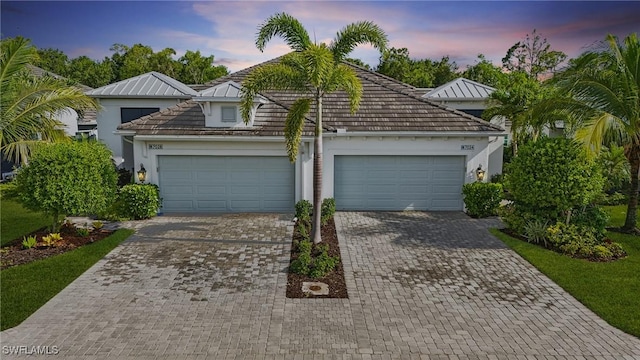 7028 Mistral Way, Fort Myers, FL 33966 - view of front facade with driveway, an attached garage, and stucco siding
