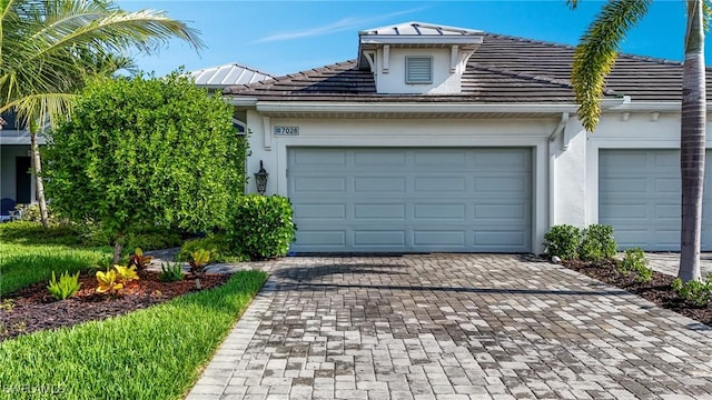 7028 Mistral Way, Fort Myers, FL 33966 - view of front of home featuring decorative driveway, an attached garage, and stucco siding