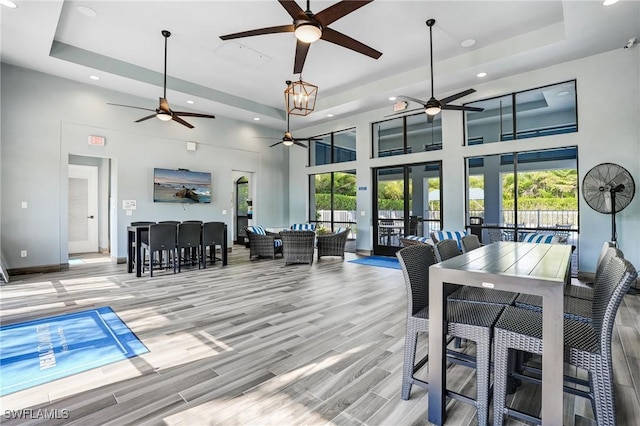 7028 Mistral Way, Fort Myers, FL 33966 - dining area featuring a ceiling fan, a tray ceiling, recessed lighting, a high ceiling, and wood finished floors