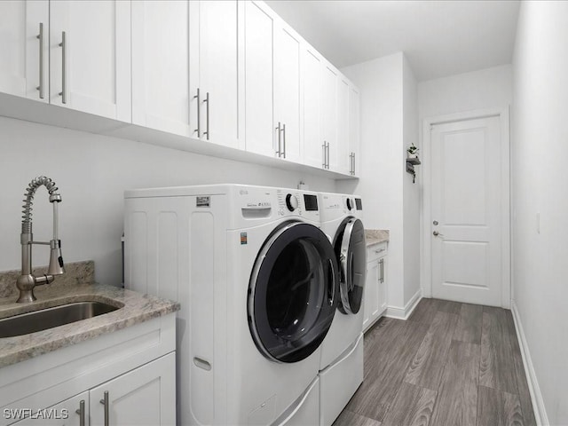 836 14th St SE, Naples, FL 34117 - laundry room with separate washer and dryer, cabinet space, light wood-type flooring, and baseboards