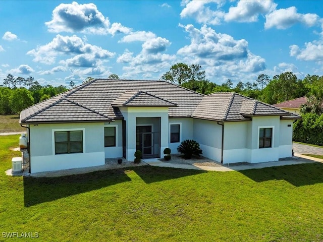 836 14th St SE, Naples, FL 34117 - view of front of home with a front lawn, a tile roof, and stucco siding