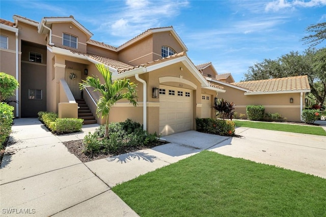 8560 Danbury Blvd Unit 202, Naples, FL 34120 - mediterranean / spanish-style home featuring stucco siding, driveway, a front yard, a garage, and a tile roof