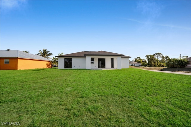 3201 14th St W, Lehigh Acres, FL 33971 - back of house featuring a lawn and stucco siding