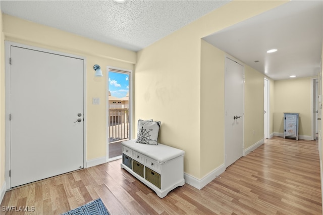 200 Periwinkle Way Unit 319, Sanibel, FL 33957 - entryway featuring light wood-type flooring, baseboards, a textured ceiling, and recessed lighting