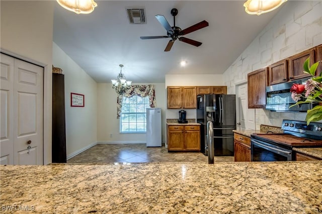 1812 SW 10th Ter, Cape Coral, FL 33991 - kitchen with appliances with stainless steel finishes, lofted ceiling, brown cabinets, ceiling fan, and a chandelier