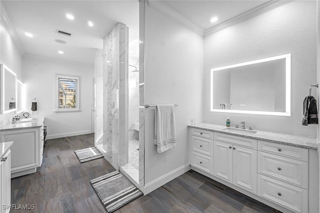 175 Topanga Dr, Bonita Springs, FL 34134 - bathroom with a marble finish shower, two vanities, crown molding, wood finished floors, and baseboards