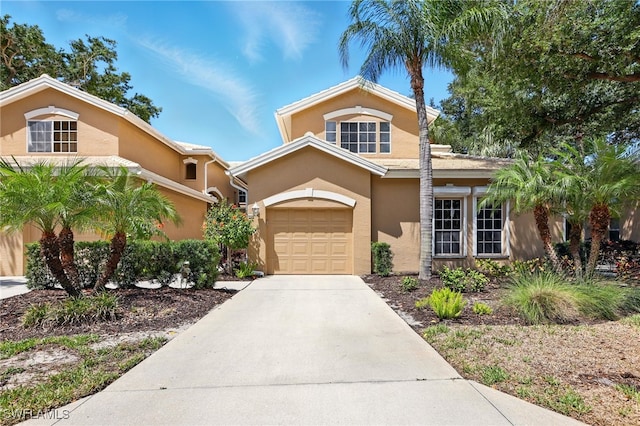 24712 Lakemont Cove Ln Unit 202, Bonita Springs, FL 34134 - view of front of house with stucco siding, driveway, and a garage