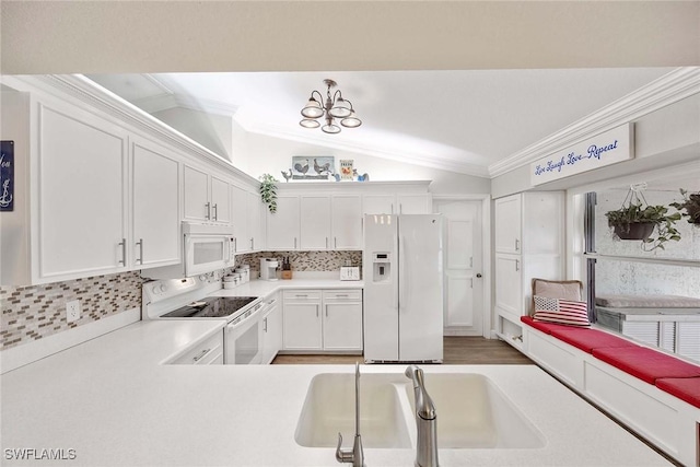 180 20th St SE, Naples, FL 34117 - kitchen featuring white appliances, vaulted ceiling, crown molding, decorative backsplash, and white cabinets