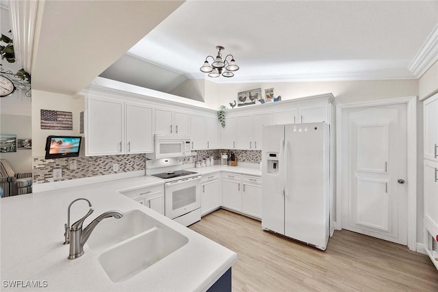 180 20th St SE, Naples, FL 34117 - kitchen with white appliances, vaulted ceiling, a sink, tasteful backsplash, and a chandelier