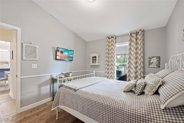 180 20th St SE, Naples, FL 34117 - bedroom with wood finished floors, baseboards, and lofted ceiling