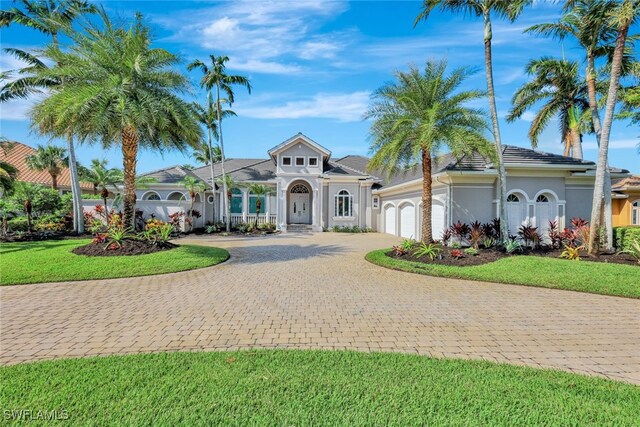 10072 Orchid Ridge Ln, Estero, FL 34135 - mediterranean / spanish-style house featuring curved driveway, an attached garage, stucco siding, and a front yard
