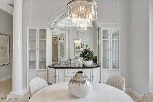 10072 Orchid Ridge Ln, Estero, FL 34135 - dining space with a chandelier, arched walkways, light tile patterned floors, and baseboards
