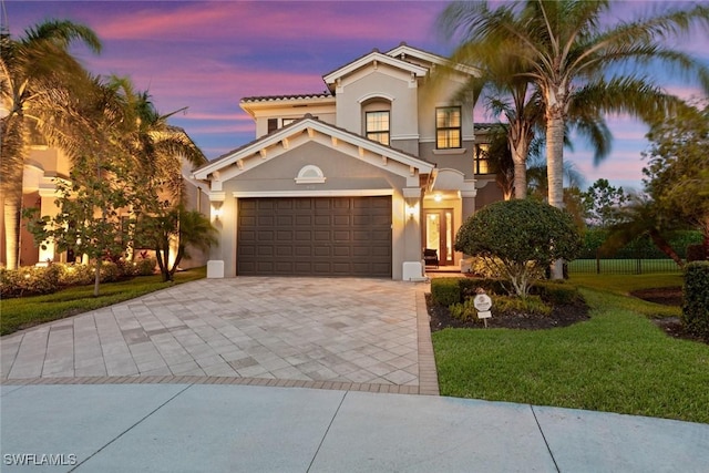 4168 Crescent Ct, Naples, FL 34119 - mediterranean / spanish-style home featuring decorative driveway, stucco siding, a front lawn, and a garage