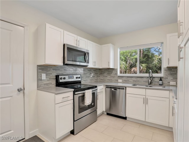 145 33rd Ave NE, Naples, FL 34120 - kitchen with stainless steel appliances, a sink, tasteful backsplash, white cabinetry, and light countertops
