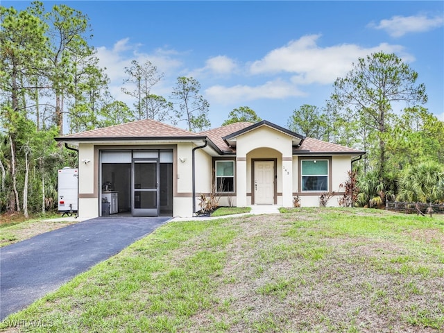 145 33rd Ave NE, Naples, FL 34120 - ranch-style house with stucco siding, driveway, a front lawn, roof with shingles, and a garage
