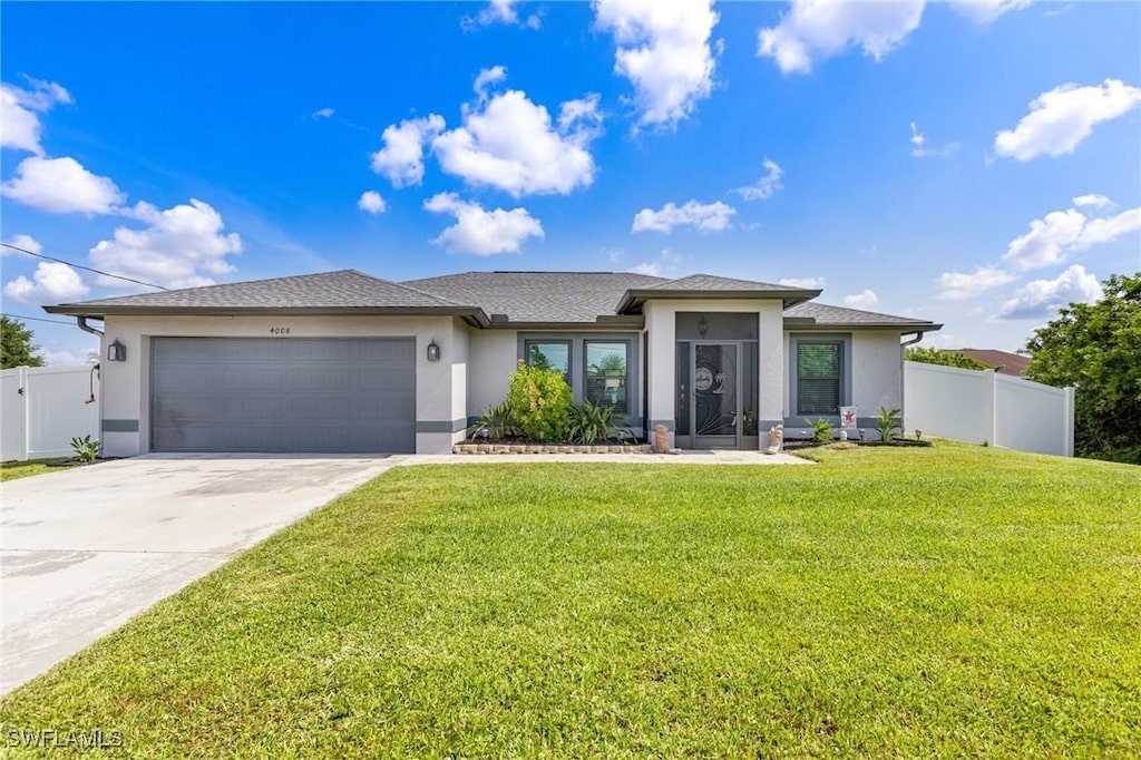 4008 27th St SW, Lehigh Acres, FL 33976 - prairie-style home with stucco siding, an attached garage, and driveway