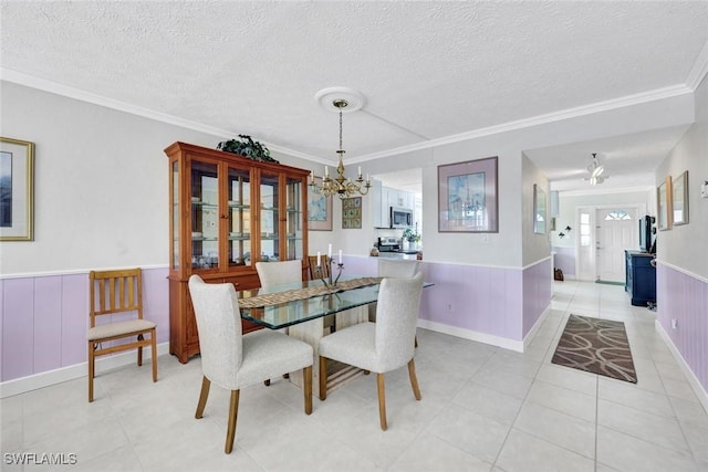 1829 SE 41st St Unit 1I, Cape Coral, FL 33904 - dining room featuring a chandelier, wainscoting, a textured ceiling, ornamental molding, and light tile patterned floors