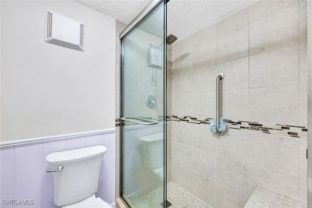 1829 SE 41st St Unit 1I, Cape Coral, FL 33904 - full bathroom featuring a shower stall, a textured ceiling, toilet, and a wainscoted wall