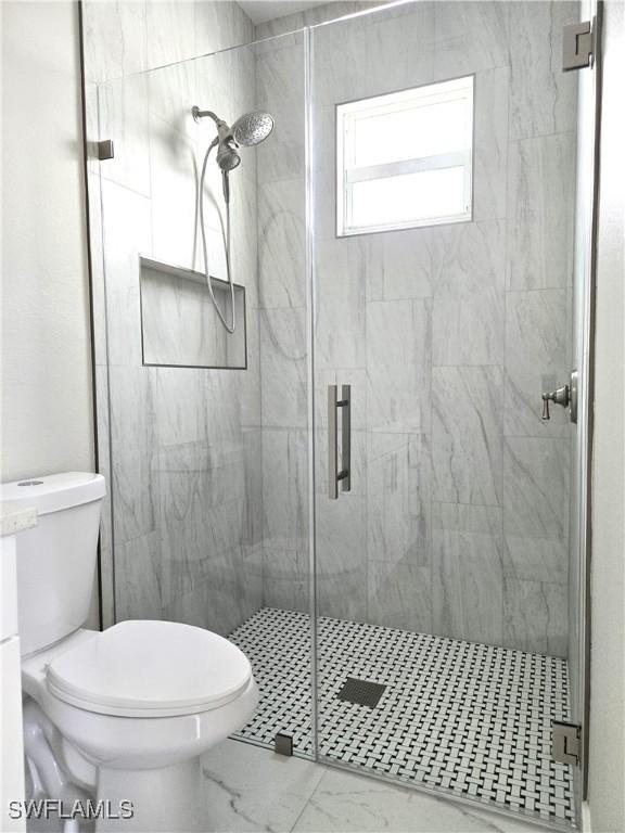 222 Victoria Ave S, Lehigh Acres, FL 33974 - full bath featuring marble finish floors, toilet, and a stall shower