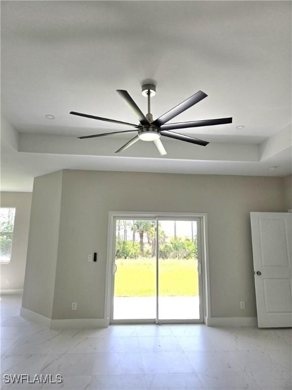 222 Victoria Ave S, Lehigh Acres, FL 33974 - unfurnished room with baseboards, light marble finish floors, ceiling fan, a tray ceiling, and recessed lighting
