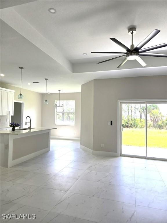 222 Victoria Ave S, Lehigh Acres, FL 33974 - unfurnished living room featuring light marble finish flooring, baseboards, a ceiling fan, recessed lighting, and a sink