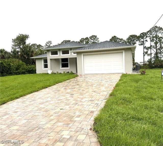 222 Victoria Ave S, Lehigh Acres, FL 33974 - prairie-style house with stucco siding, a front lawn, decorative driveway, and an attached garage
