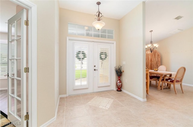 3708 SW 2nd Ln, Cape Coral, FL 33991 - entryway with french doors, light tile patterned floors, baseboards, and a chandelier