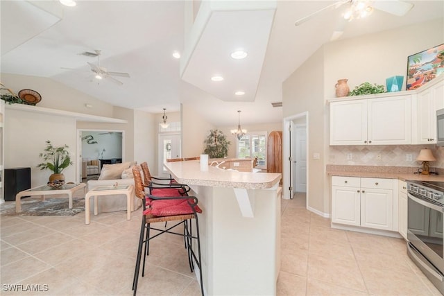 3708 SW 2nd Ln, Cape Coral, FL 33991 - kitchen featuring ceiling fan, stainless steel electric stove, vaulted ceiling, light tile patterned flooring, and white cabinetry