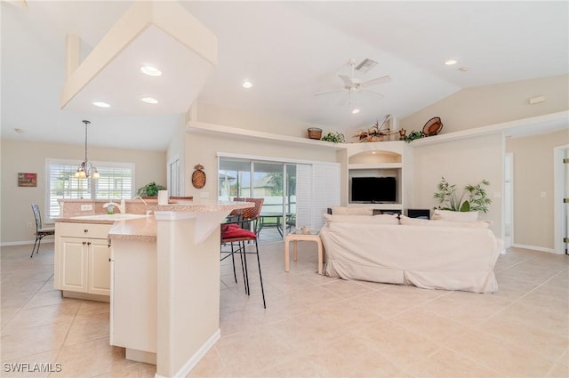 3708 SW 2nd Ln, Cape Coral, FL 33991 - kitchen with vaulted ceiling, light tile patterned floors, light countertops, ceiling fan, and a breakfast bar