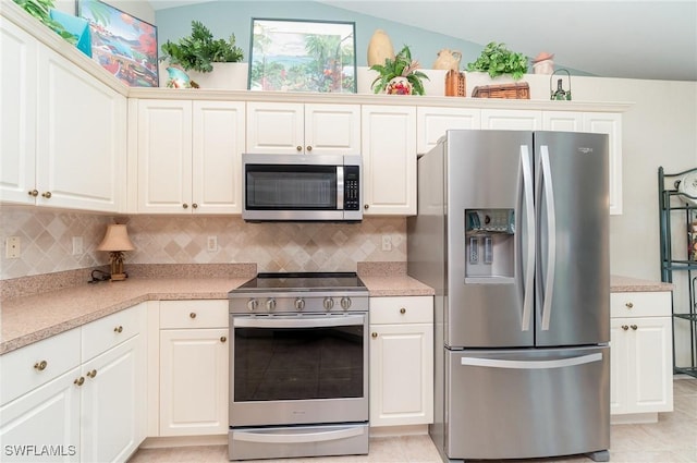 3708 SW 2nd Ln, Cape Coral, FL 33991 - kitchen featuring appliances with stainless steel finishes, vaulted ceiling, decorative backsplash, and light countertops