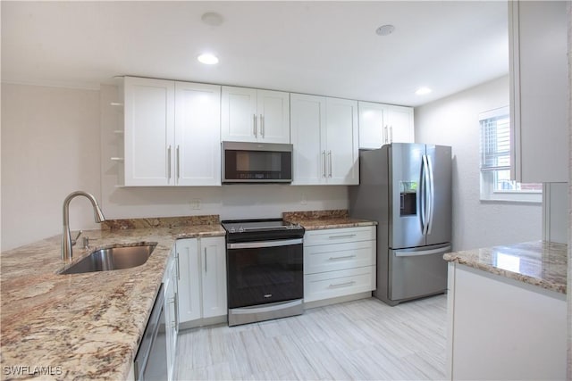 632 Victoria Dr Unit 103, Cape Coral, FL 33904 - kitchen featuring stainless steel appliances, a sink, open shelves, white cabinetry, and light stone counters
