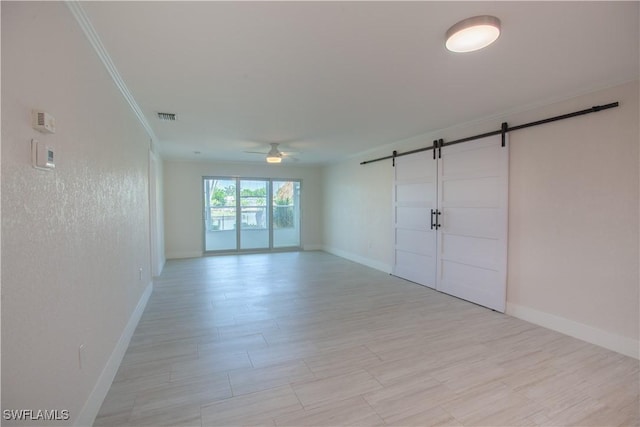 632 Victoria Dr Unit 103, Cape Coral, FL 33904 - spare room featuring a barn door, a ceiling fan, baseboards, ornamental molding, and light wood-style floors