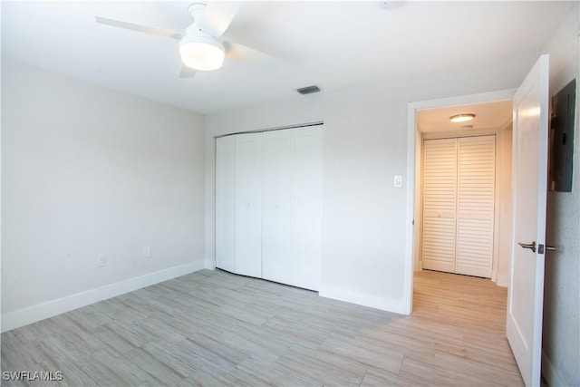 632 Victoria Dr Unit 103, Cape Coral, FL 33904 - unfurnished bedroom with baseboards, light wood-style flooring, a closet, a ceiling fan, and electric panel