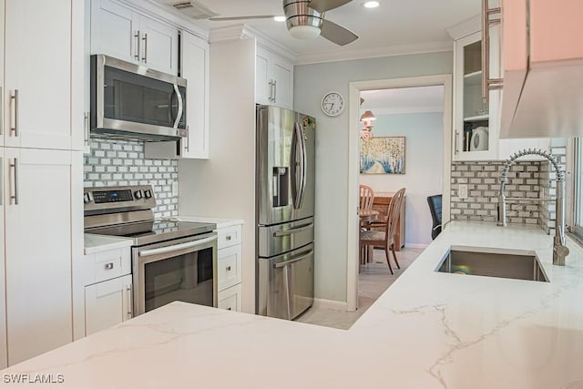67 Pebble Beach Blvd, Naples, FL 34113 - kitchen with stainless steel appliances, a sink, ornamental molding, ceiling fan, and backsplash