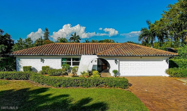 67 Pebble Beach Blvd, Naples, FL 34113 - mediterranean / spanish-style house featuring a tile roof, an attached garage, driveway, and a front lawn