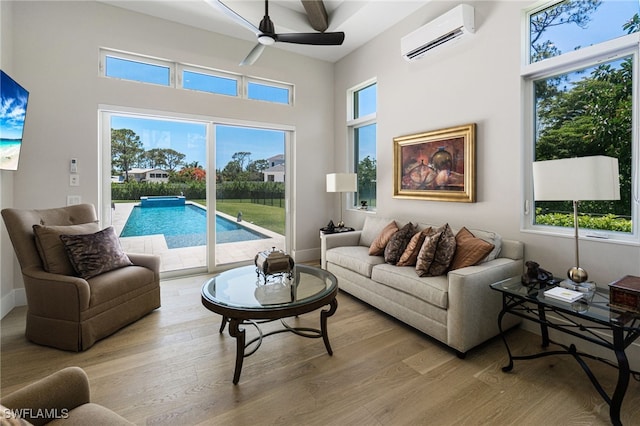 493 Myrtle Rd, Naples, FL 34108 - living area featuring a wall mounted air conditioner, a ceiling fan, light wood-style floors, baseboards, and a high ceiling