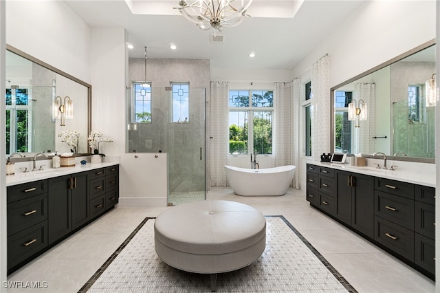 493 Myrtle Rd, Naples, FL 34108 - full bathroom with inlaid floor details, a stall shower, two vanities, a freestanding tub, and recessed lighting