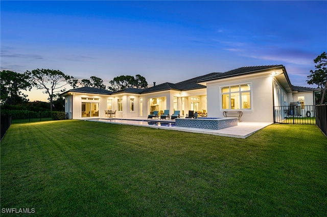 493 Myrtle Rd, Naples, FL 34108 - back of property at dusk with stucco siding, a patio area, and outdoor lounge area