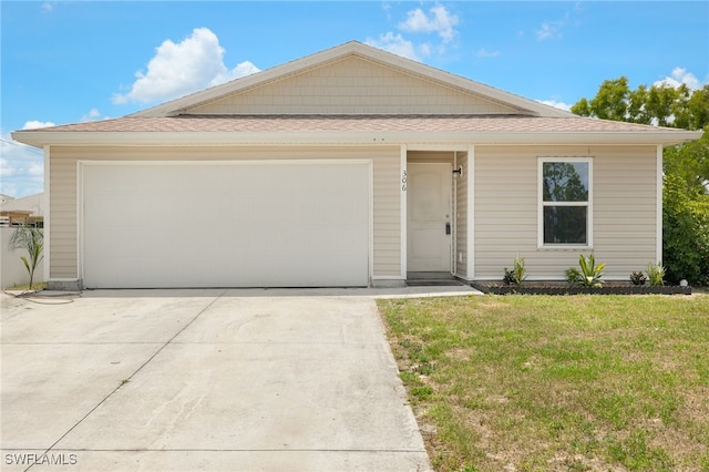 306 Wilmington Pkwy, Cape Coral, FL 33993 - view of front of home featuring concrete driveway, a front yard, roof with shingles, and an attached garage