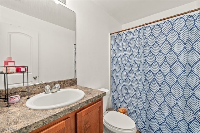 306 Wilmington Pkwy, Cape Coral, FL 33993 - full bath featuring toilet, vanity, and a shower with shower curtain