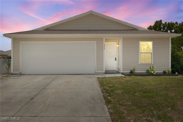 306 Wilmington Pkwy, Cape Coral, FL 33993 - view of front facade with driveway, a yard, a shingled roof, and a garage